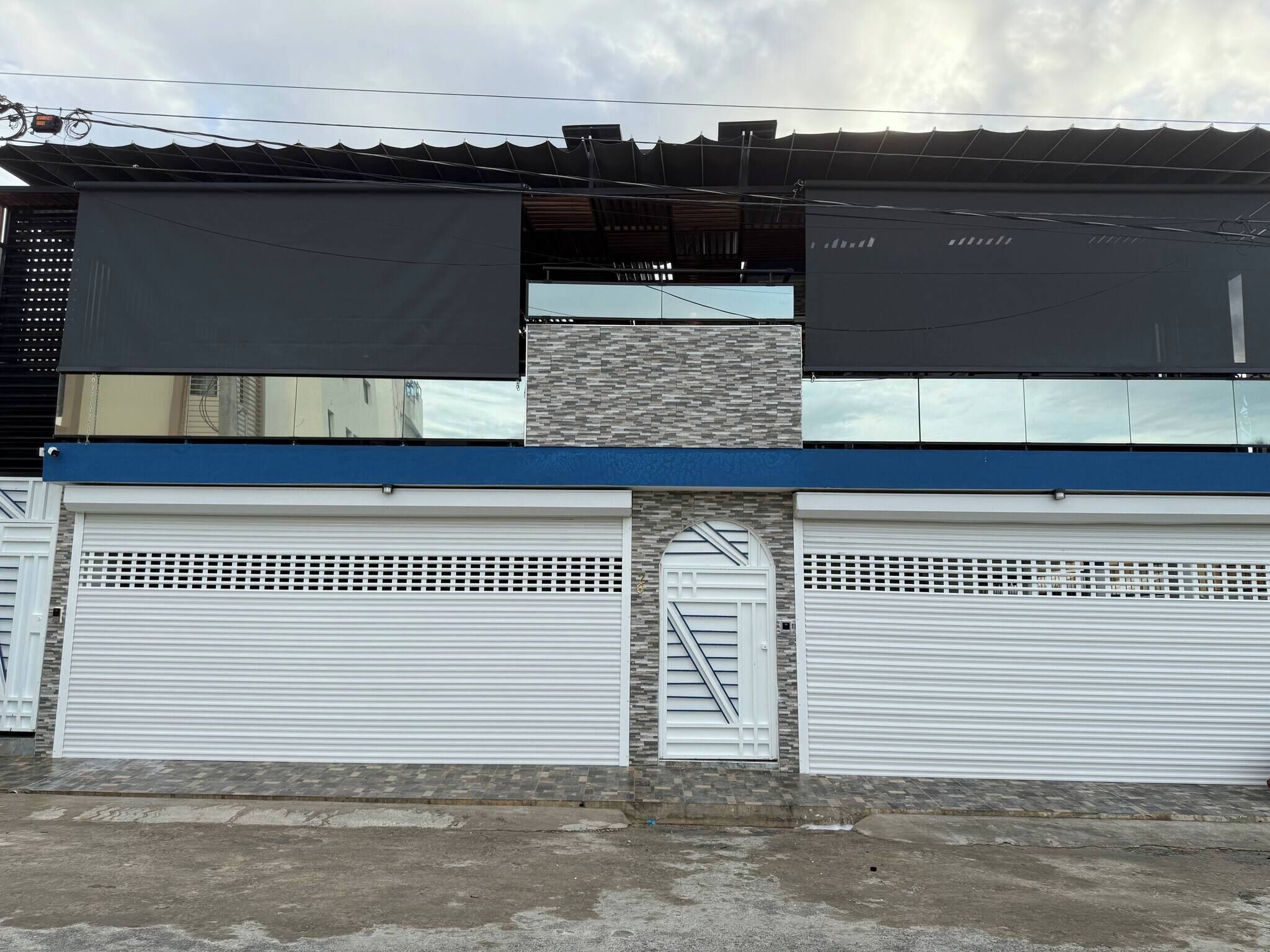 A building with a flat roof, two garage doors, and a visible staircase.