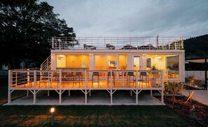 A modern, two-story house with a balcony and outdoor seating area. - THOUSANDGARDENTARUMIZU (Tarumizu)