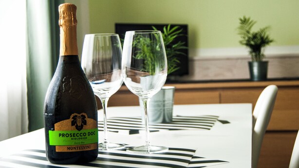 Eine Flasche Prosecco DOC mit zwei Gläsern auf einem Tisch.