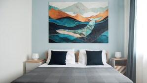 Ein Schlafzimmer mit einem Bett, zwei Nachttischen und einem an der Wand hängenden abstrakten Gemälde.