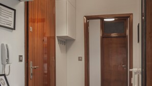 Ein Flur mit Mosaikboden, Holztüren und einem weißen Empfangsschalter mit Telefon.