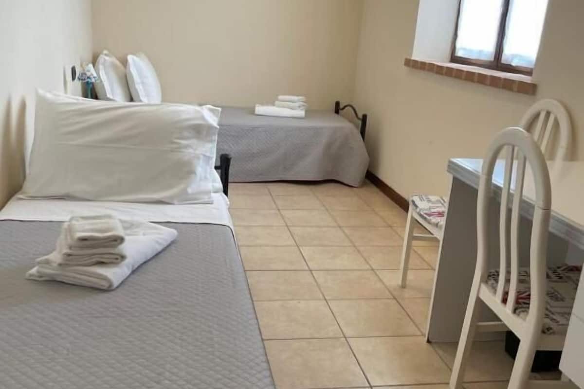 Une chambre avec deux lits, un bureau et une chaise.