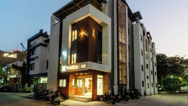 A modern building with a sign reading 'treebo HUB' and a staircase leading to the entrance. - Treebo Hub (Indore)