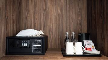 A microwave with a Great Lock, two white mugs, a coffee maker, a glass carafe, and a coffee pod on a tray.