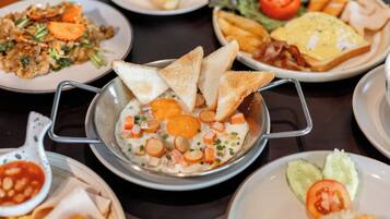 A variety of dishes on a table, including a bowl of soup with vegetables and eggs, toast, and other food items.