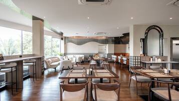 A spacious restaurant with high ceilings, large windows, and a modern interior design.