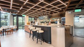 A modern bar area with a counter, stools, and a view of the outdoors.