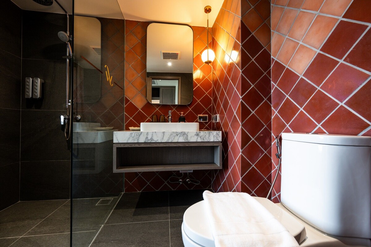 Ein modernes Badezimmer mit einer Duschkabine, einem мраморным Waschbecken und einer weißen Toilette.