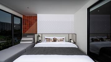 Habitación de hotel moderna con una cama grande, un sofá y vistas a la ciudad.