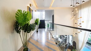 Een modern interieur met glazen balustrade, een trap en potplanten.