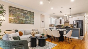 Uma sala de estar moderna com sofá, mesa de centro e área de jantar com cadeiras.