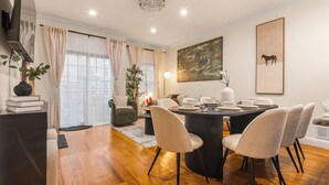 Uma área de jantar com uma mesa redonda, quatro cadeiras e um lustre.