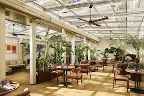 A spacious indoor area with high ceilings, large windows, and multiple seating arrangements. - Nh Marbella (Marbella)