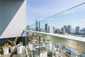 Ein Balkon mit Blumentöpfen und Blick auf die Stadt.