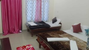 A room with a bed, a sofa, a table, and curtains.
