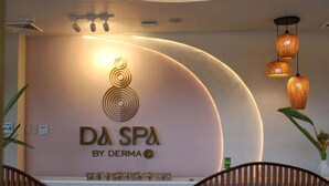 A reception area with a curved wall, a logo, and a reception desk. - Dahican Beach Resort and Spa (Mati)