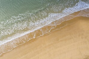 Eine Luftaufnahme eines Strandes, der durch eine deutliche Linie vom Meer getrennt ist.