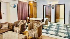 Ein geräumiges Wohnzimmer mit Essbereich, ausgestattet mit einem großen Fenster, einem Deckenventilator und einem gemusterten Boden.