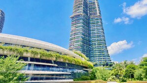 Un immeuble moderne de grande hauteur, doté d’une façade incurvée et de jardins verticaux.