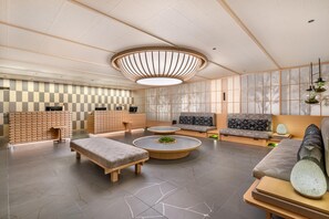 A modern interior with a checkered wall, round tables, sofas, and a unique ceiling light fixture. - Hilton Grand Vacations Club Tradimo Kyoto Gojo (Kyoto)