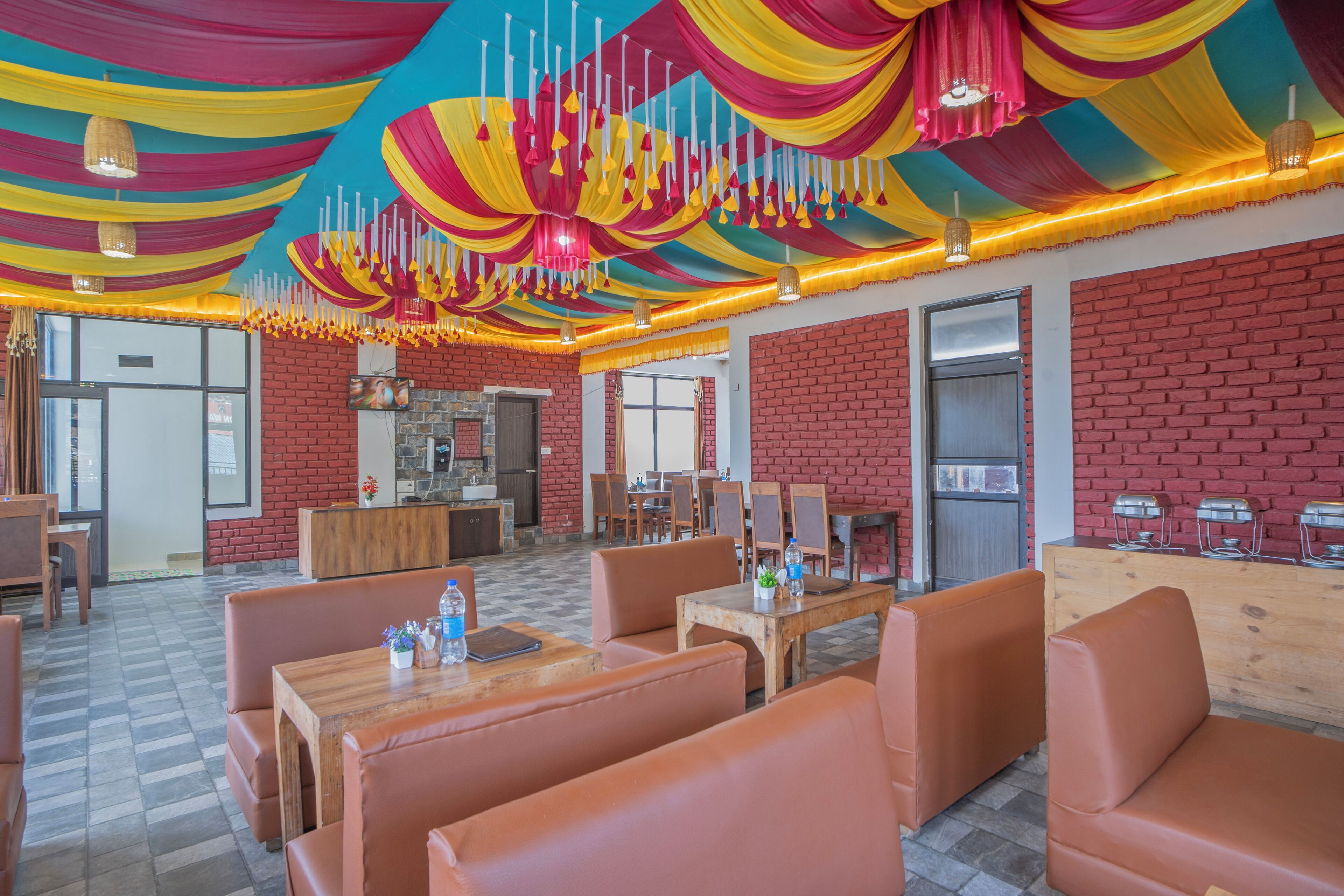 Un restaurant aux murs de briques, aux tables en bois et aux fauteuils en cuir orange.