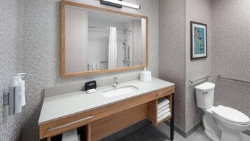 A modern bathroom with a wooden vanity, white sink, and a toilet.