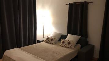 Une chambre à coucher avec un lit, deux oreillers, une table de chevet et une lampe.