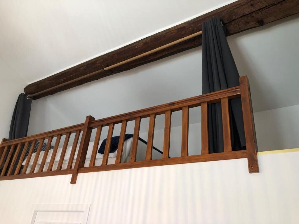 Een houten balkonhek met een witte deur eronder.