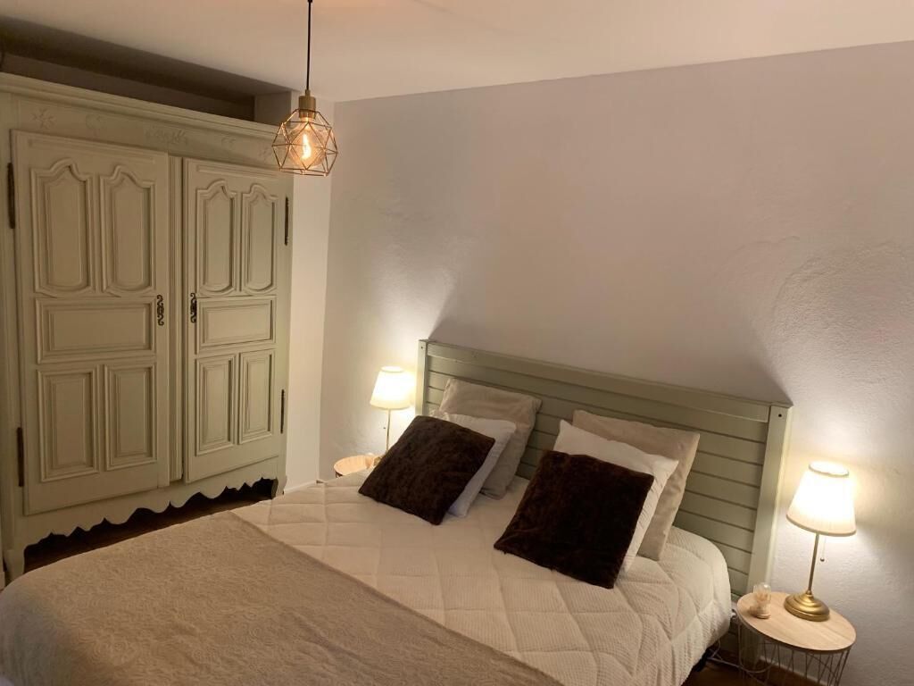 Una camera da letto con un letto, due lampade da comodino, un comodino e un armadio.