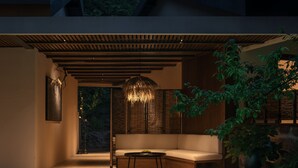 A modern outdoor seating area with a pool, a hanging light fixture, and a potted plant. - Xishan Cloister (Chengdu)