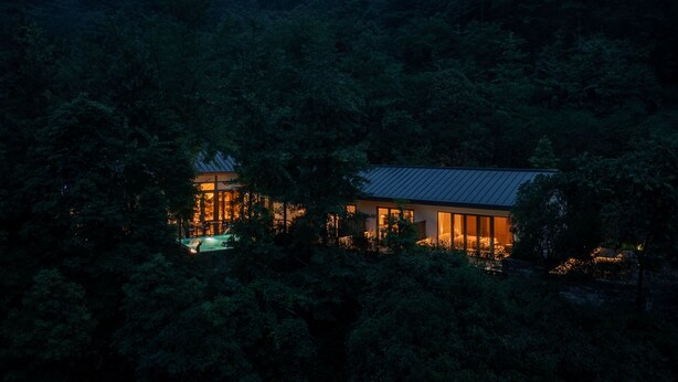 A modern house surrounded by dense forest at dusk. - Xishan Cloister (Chengdu)