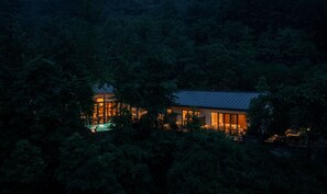 A modern house surrounded by dense forest at dusk. - Xishan Cloister (Chengdu)