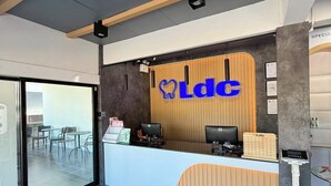 Un comptoir d’accueil moderne, doté d’un logo, d’ordinateurs et d’une balance.