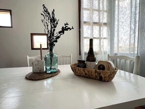 A dining table with a vase of dried flowers, a candle, and a basket of bread. - Villa with pool, views, barbeque and wifi (Pájara)