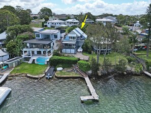 A residential area with houses, a swimming pool, and a dock extending into a body of water.