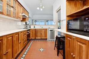 A kitchen with wooden cabinets, a built-in microwave, and a tiled backsplash.