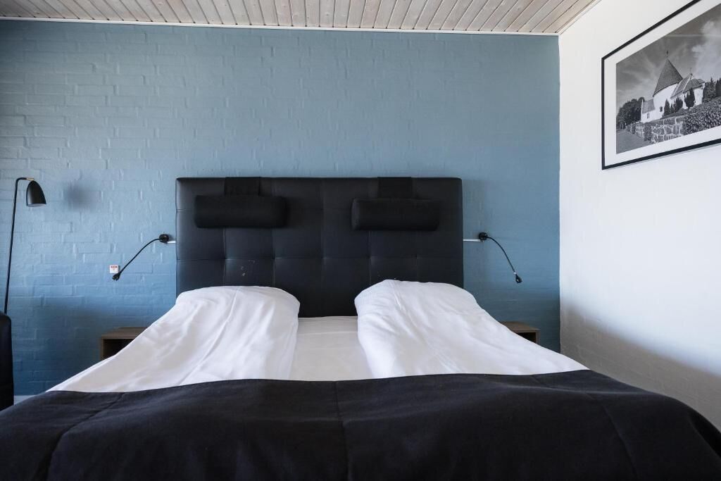 Un dormitorio con una cama grande, dos lámparas de noche y un cuadro en la pared.