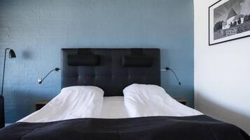 Un dormitorio con una cama grande, dos lámparas de noche y un cuadro en la pared.