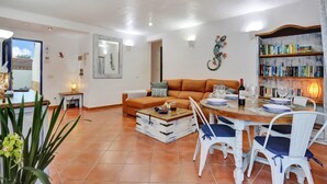 Ein Wohnzimmer mit einer Couch, einem Couchtisch und einem Essbereich mit Stühlen und einem Tisch, der für eine Mahlzeit gedeckt ist.