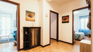 Un pasillo con chimenea, una puerta y una cama en la habitación contigua.