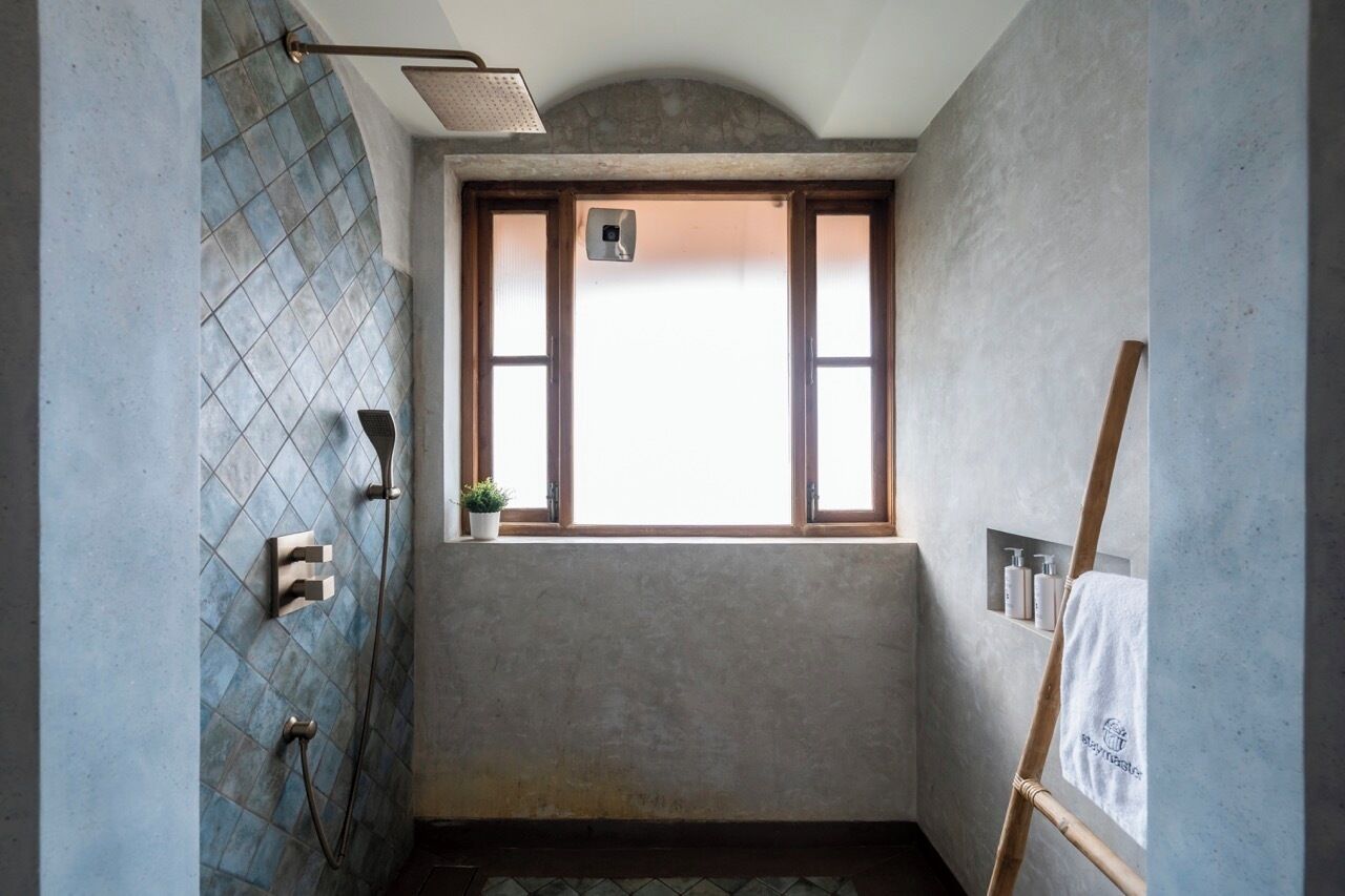 Une salle de bain avec une douche, une fenêtre et un porte-serviettes.