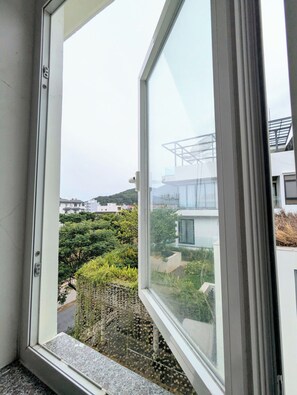 A window with a view of a residential area, including houses and greenery. - AN Apartment (Son Tra)