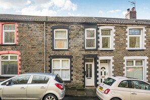 A row of terraced houses with stone facades, white-framed windows, and a chimney. - Valley views, hot tub and pool table — sleeps 8 in the Welsh hills (Cwmaman)