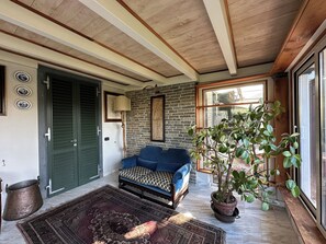 A room with a wooden ceiling, a blue sofa, a potted plant, and a large window. - Villa Mariapia 6P, by VILLASRETREATS Beach house, a few steps from the sea (Massa)
