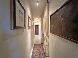A hallway with framed artwork, a patterned carpet, and a door at the end. - Villa Mariapia 6P, by VILLASRETREATS Beach house, a few steps from the sea (Massa)