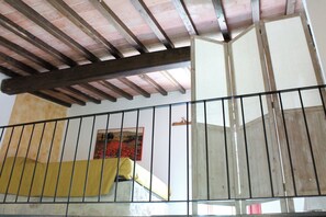 A staircase with a metal railing, wooden beams, and a yellow cloth on the steps. - The small mill on the Argenna stream in the woods of Chianti in Tuscany (Toscana)