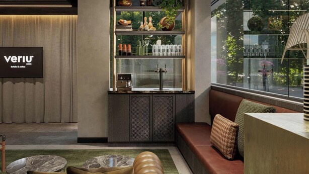 A modern hotel lobby with a reception desk, seating area, and a display of amenities. - Veriu Richmond (Richmond)