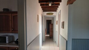 Ein schmaler Flur mit Holzausbau und Fliesenboden.