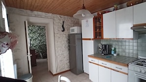 A kitchen with white cabinets, a stainless steel refrigerator, a gas stove, and a microwave. - Au Calme 4 star house 2 bedrooms large swimming pool 6x12 m sea and town 1,5 km (Saint-Pierre-d'Oléron)