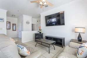 Ein Wohnzimmer mit einer Couch, einem Couchtisch, einem Fernseher und einem Kamin.